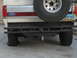 1990 Ford Bronco - The rear of a Ford Bronco shows a spare tire and a custom bumper, with a North Dakota license plate visible.