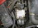 1987 Ford Bronco - This image shows a close-up view of an engine compartment with an alternator and several hoses visible.