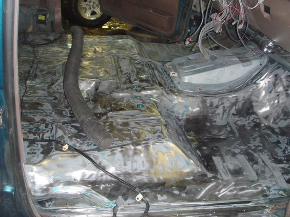 1996 Ford Bronco interior floor stripped down for restoration, showing bare metal and wiring