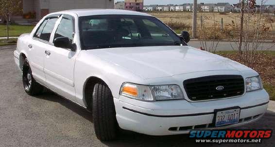 White sedan, front 3/4 view, parked on asphalt. License plate visible