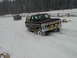 1979 Ford Bronco - A brown Ford Bronco navigates through deep snow, with another vehicle following in the background.