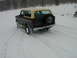 1979 Ford Bronco - A Ford Bronco navigates a snowy path, kicking up snow as it drives.