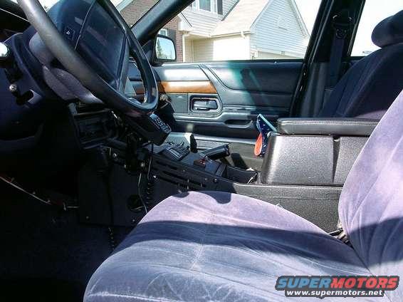 Interior view of a 1999 Ford Crown Victoria police car, showing the dashboard and center console