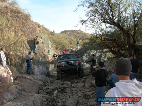 Dark blue pickup truck navigating a rocky off-road trail