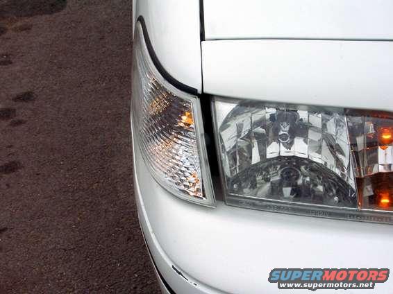 White car front corner, clear turn signal and headlight. 1999 Ford Crown Victoria