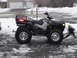 1979 Ford Bronco - A black Polaris all-terrain vehicle equipped with a snow plow attachment sits in a driveway covered in snow.