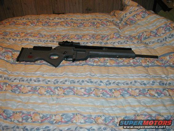 Sniper rifle with scope on a patterned comforter