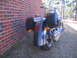 2006 Victory Kingpin - A motorcycle is parked next to a brick wall, with saddlebags and dual exhaust pipes visible from the rear.