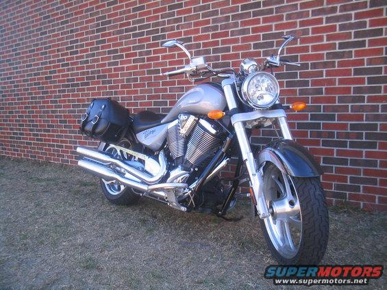 Silver 2006 Victory Kingpin motorcycle with black saddlebags parked in front of a brick wall