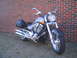 2006 Victory Kingpin - A silver 2006 Victory Kingpin motorcycle with black saddlebags is parked outdoors in front of a brick wall.