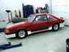 1990 Ford Mustang - A modified 1990 Ford Mustang sits in a garage, a prominent hood scoop and custom paint.