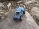 1996 Ford Bronco - A remote-controlled pickup truck navigates a rocky terrain with debris in the background.