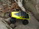 1996 Ford Bronco - A yellow remote control rock crawler with black flame decals navigates a rocky terrain.