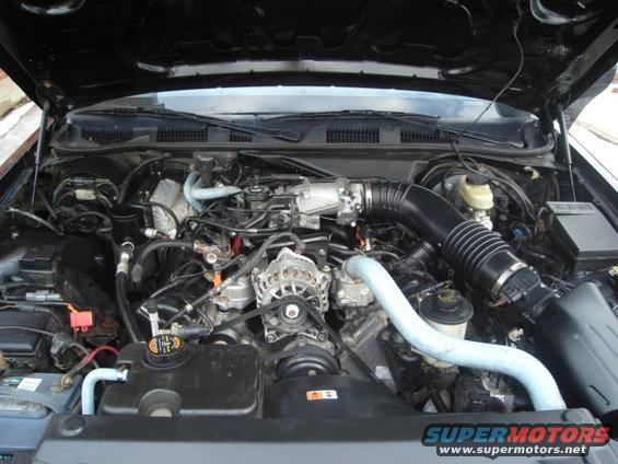 Engine bay with V8 engine, air intake, and battery