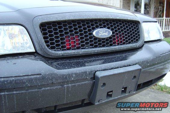 Black 2003 Ford Crown Victoria front grille with honeycomb pattern and red accents