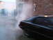 1983 Mazda RX-7 - A black 1983 Mazda RX-7 is seen from the rear, with smoke billowing around it.