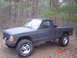 1988 Jeep Comanche - This Jeep pickup truck, likely from the mid-1980s, is shown from a three-quarter front angle in a forest setting.
