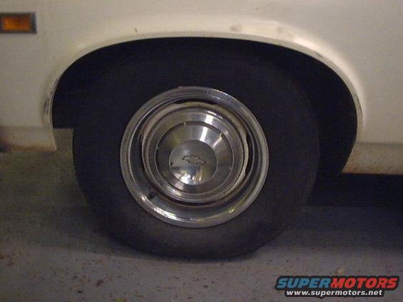 White 1969 Chevrolet Nova rear wheel and fender with chrome hubcap