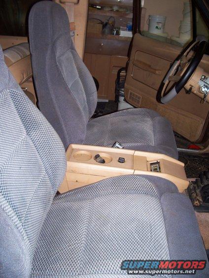 Interior shot of a vehicle, showing front seats, center console with cup holders, and steering wheel