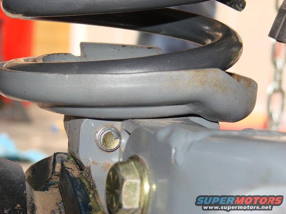 Close-up of a gray suspension component with a coil spring