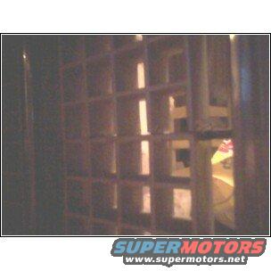 Close-up of a square-patterned grille with SuperMotors logo visible