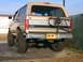 1996 Ford Bronco - This lifted Ford Bronco has a spare tire mounted on the rear and large off-road tires.