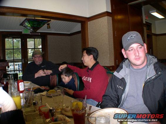 People seated at a restaurant table with food and drinks
