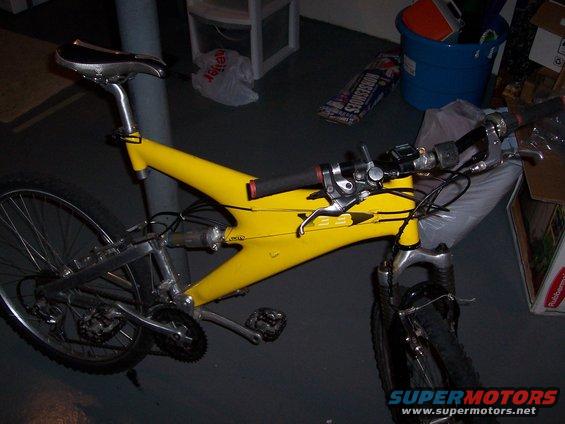Yellow bicycle frame with silver components, seen from the side