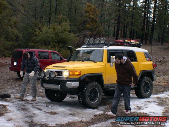 Yellow 2007 Toyota FJ Cruiser with roof rack and snorkel parked in a wooded area