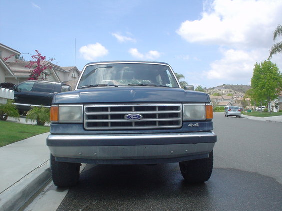 Front view of a blue Ford F-Series truck. Grille has Ford logo. 4x4 badge visible on front