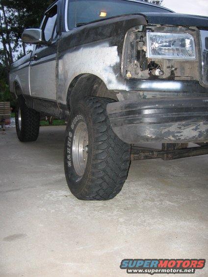Truck front fender and wheel, missing headlight assembly, with body filler on fender