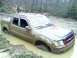 2002 Ford Sport Trac - This 2002 Ford Sport Trac is deeply stuck in mud, with another vehicle visible in the wooded background.