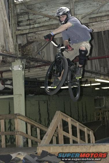 BMX rider in mid-air over wooden ramps