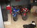 2005 Yamaha R1 - Two sport motorcycles are parked inside a room, with a dog lying on the floor nearby.