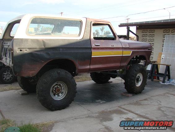 1979 Ford Bronco side view, lifted with large tires and two-tone paint