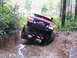 1989 Ford Bronco - This modified SUV navigates a challenging off-road trail with one wheel high in the air.