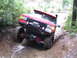 1989 Ford Bronco - A red 1989 Ford Bronco navigates a steep, muddy off-road trail with large tires and a snorkel.