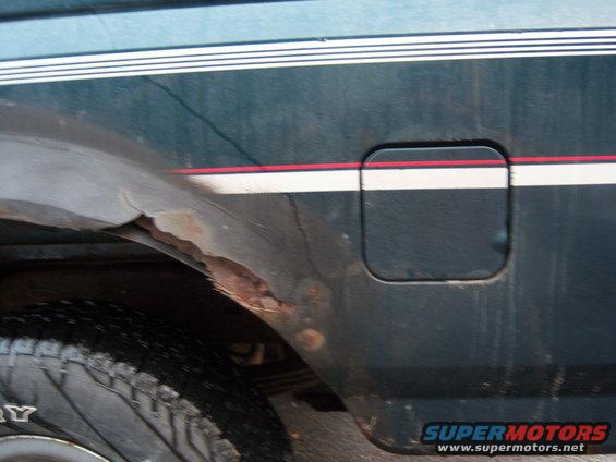 1995 Ford Bronco side view showing fuel door and rusty rear wheel well