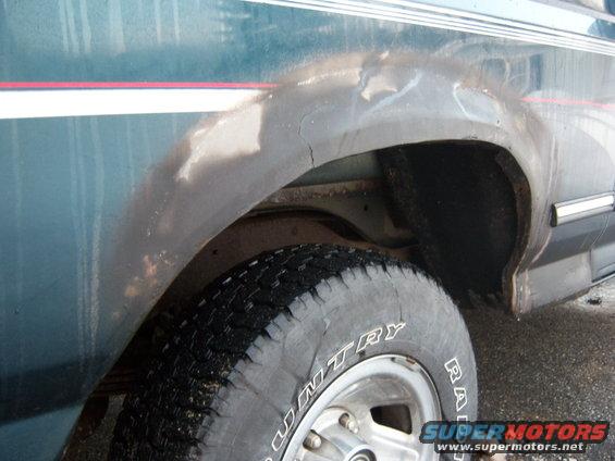 1995 Ford Bronco rear wheel well showing rust and damage