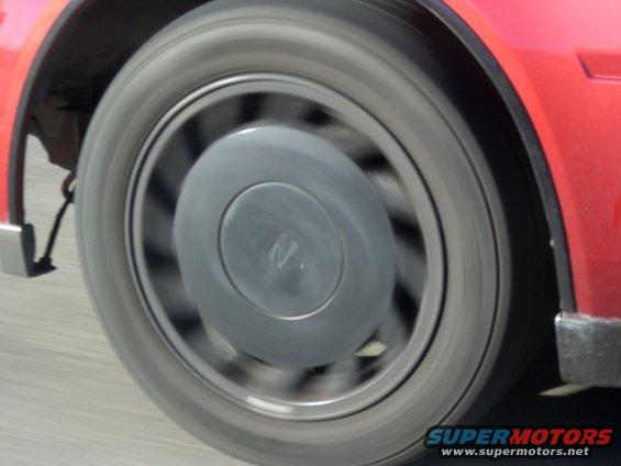 Red car wheel with a gray hubcap showing an 'N' logo