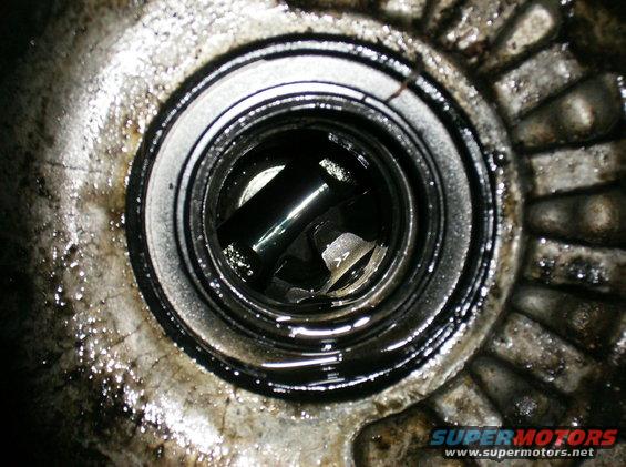 Greasy mechanical part with a shaft visible inside a circular opening
