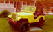 1970 Mercury Cougar - A yellow Jeep CJ is parked in front of a house. The vehicle has a black roll bar and large off-road tires.