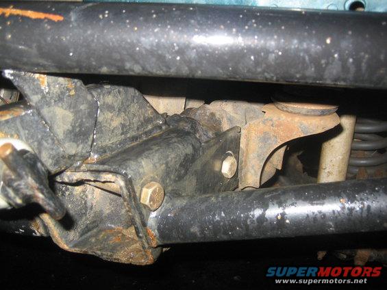 Undercarriage part with rust and bolts, viewed from below