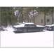 1973 Ford Ranchero - A dark coupe with a white roof sits covered in snow next to another vehicle in a yard.