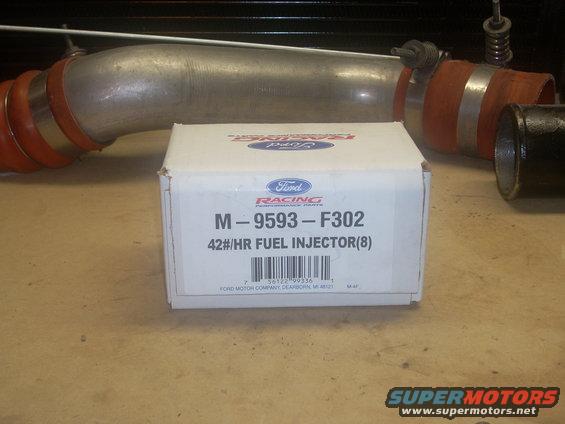 Box of Ford Racing 42 lb/hr fuel injectors (8) and a metal intake pipe with orange couplers