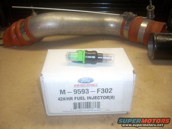 Ford Racing fuel injector box with a single injector on top, next to a large metal intake pipe
