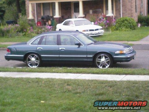 1995 Ford Crown Victoria parked on street, another white car behind it