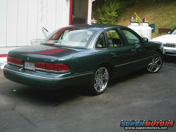 Green 1995 Ford Crown Victoria rear 3/4 view with chrome wheels
