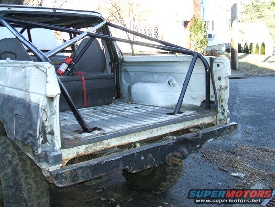 White 1995 Ford Bronco rear view with custom roll cage and fire extinguisher