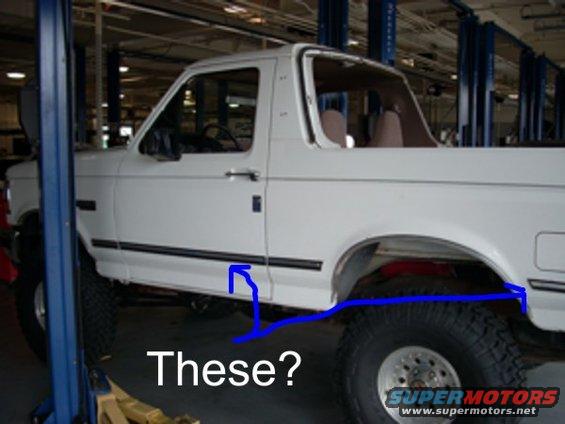 White 1992 Ford Bronco on a lift, with blue lines drawn on the lower body and rear fender area. Text reads 'These?'